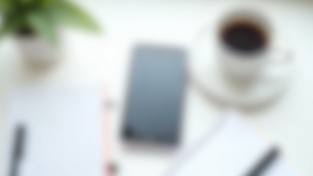 Smartphone på hvidt bord med notesblok, pen og kaffekop på siden